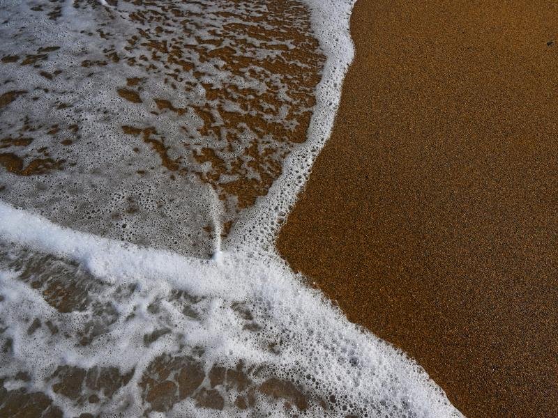 a wave washing across sand
