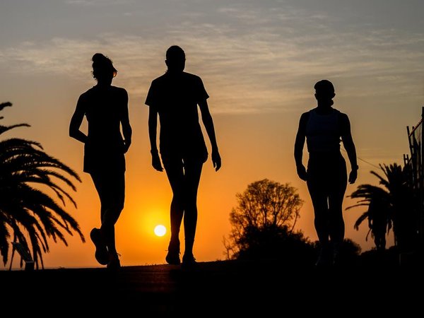 People exercise against the sunrise at Cronulla Beach in Sydney